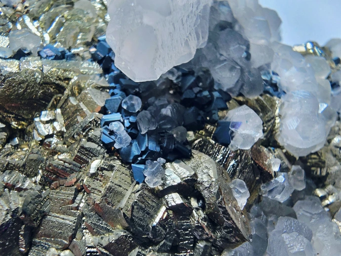 Close-up of metallic pyrite crystals with quartz and blue minerals